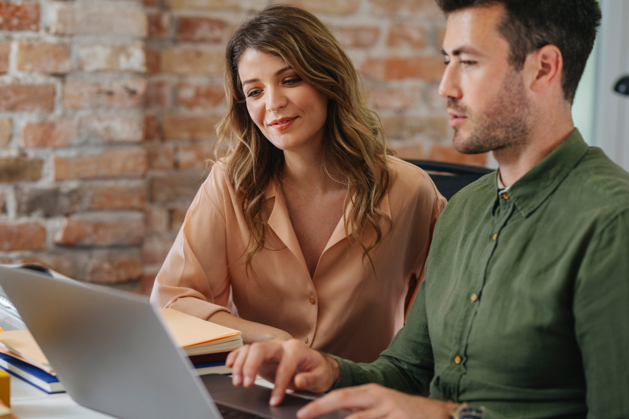 Two executives looking at call insights data from RingCentral ACE on a laptop